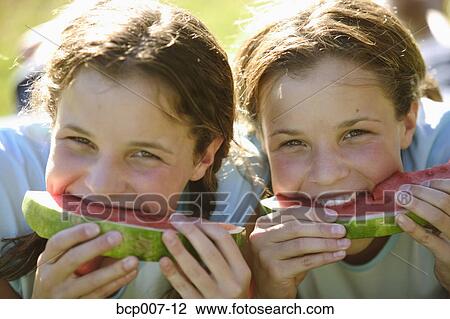 Twin teenage girls eating slices of watermelon. View Large Photo Image Stock Image - Twin teenage girls eating slices of watermelon.. Fotosearch