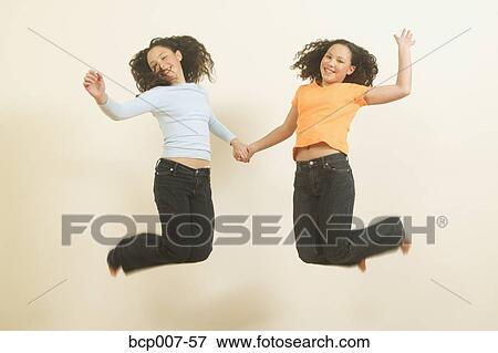 Twin teenage girls leaping in the air. View Large Photo Image Stock Photo - Twin teenage girls leaping in the air.. Fotosearch