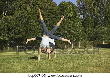 Twin teenage girls turning cartwheels in park. View Large Photo Image Stock Photography - Twin teenage girls turning cartwheels in park.. Fotosearch