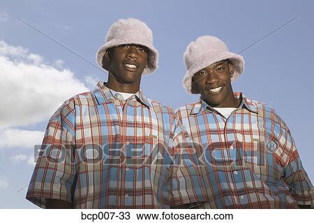Twin teens in matching hats and shirts. View Large Photo Image Stock Image - Twin teens in matching hats and shirts.. Fotosearch