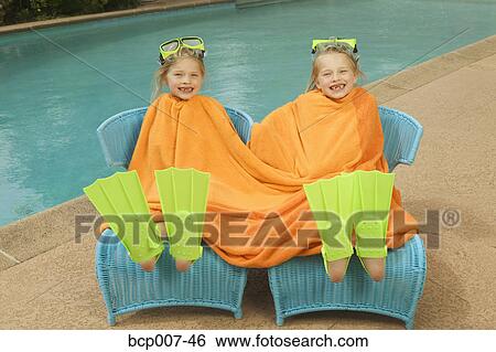 Young, twin girls share a towel poolside. View Large Photo Image Stock Photograph - Young, twin girls share a towel poolside.. Fotosearch