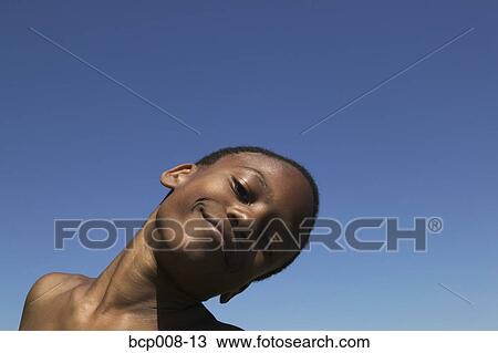 Stock Image - Young boy smiling outdoors.. Fotosearch