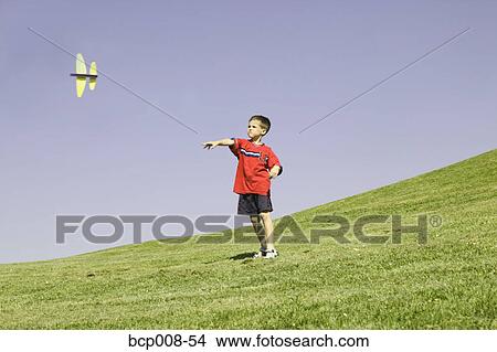 Picture - Young boy watching his model plane fly.. Fotosearch