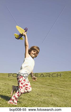 Young girl holding a toy airplane. View Large Photo Image Stock Photography - Young girl holding a toy airplane.. Fotosearch