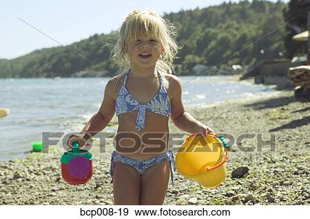 Young girl holding beach toys. View Large Photo Image Stock Photo - Young girl holding beach toys.. Fotosearch