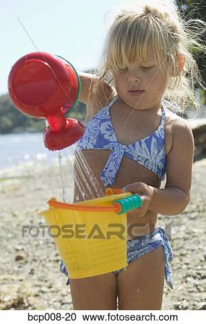 Stock Image - Young girl playing at the beach.. Fotosearch