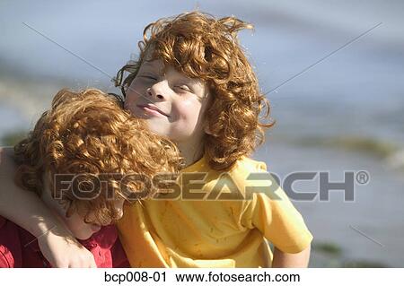 Stock Image - Young red-headed brothers on a beach.. Fotosearch