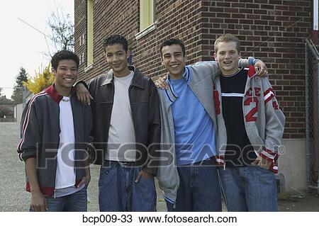 Stock Image - Smiling teenage boy and his pals.. Fotosearch