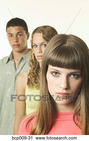 Stock Image - Studio portrait of three teens.. Fotosearch