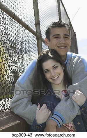 Teen couple leaning against a fence. View Large Photo Image Stock Image - Teen couple leaning against a fence.. Fotosearch