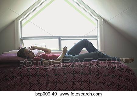 Teen listening to music on her bed. View Large Photo Image Stock Photo - Teen listening to music on her bed.. Fotosearch