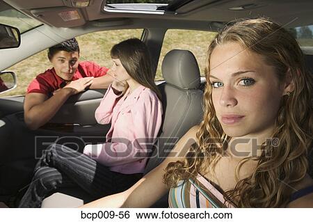 Stock Photograph - Teenage girls in a car and their friend.. Fotosearch