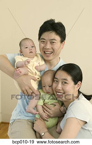A couple embracing their twin babies. View Large Photo Image Stock Photo - A couple embracing their twin babies.. Fotosearch