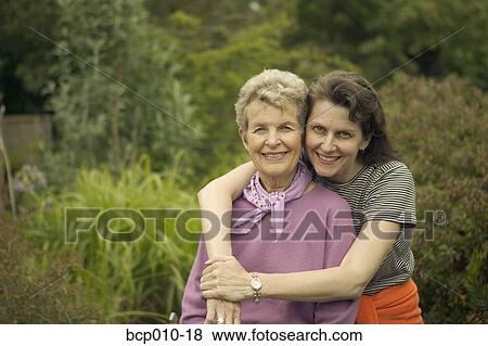 A mother being embraced by her adult daughter. View Large Photo Image Stock Photo - A mother being embraced by her adult daughter.. Fotosearch