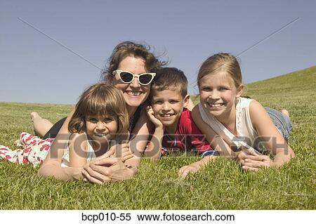 A mother laying in the sun with three children. View Large Photo Image Stock Photography - A mother laying in the sun with three children.. Fotosearch