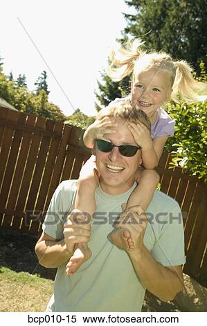 Father giving his young daughter a ride on his shoulders. View Large Photo Image Stock Photography - Father giving his young daughter a ride on his shoulders.. Fotosearch