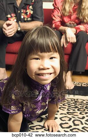 Stock Image - Girl with her parents in the background.. Fotosearch