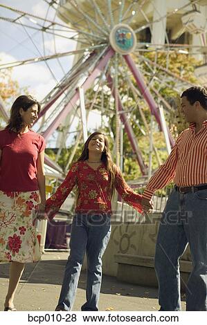 Parents and daughter at an amusement park. View Large Photo Image Stock Photo - Parents and daughter at an amusement park.. Fotosearch
