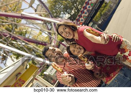 Parents and daughter eating at an amusement park. View Large Photo Image Stock Image - Parents and daughter eating at an amusement park.. Fotosearch