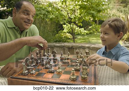 Senior man playing chess with his young grandson. View Large Photo Image Stock Image - Senior man playing chess with his young grandson.. Fotosearch