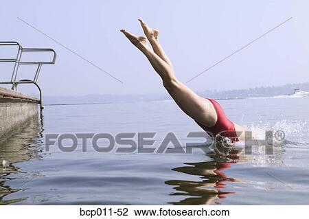 Stock Image - A woman diving into a lake.. Fotosearch