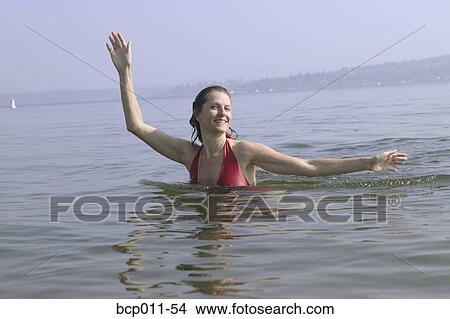 A woman swimming and posing in a lake. View Large Photo Image Picture - A woman swimming and posing in a lake.. Fotosearch