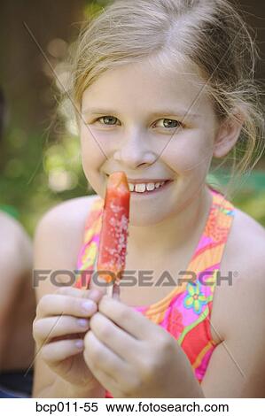A young girl holding a popsicle. View Large Photo Image Stock Photography - A young girl holding a popsicle.. Fotosearch
