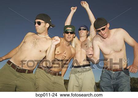 Picture - Four shirtless men dancing outdoors.. Fotosearch