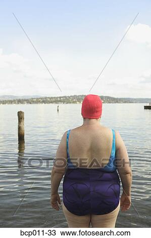 Stock Image - Rear view of a large woman in a bathing suit.. Fotosearch