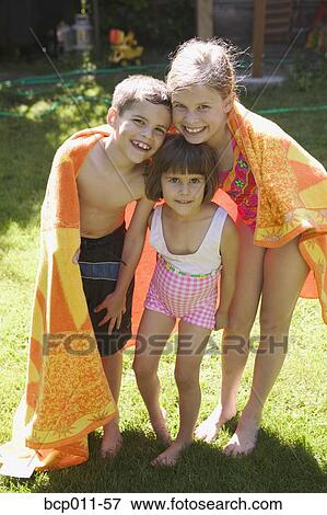 Stock Photo - Three children wrapped in a towel.. Fotosearch