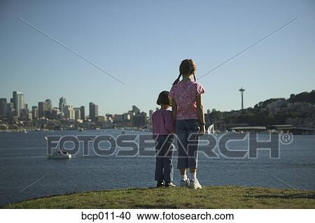Two young girls gazing at a city skyline. View Large Photo Image Stock Image - Two young girls gazing at a city skyline.. Fotosearch