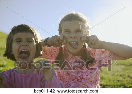 Two young girls making faces. View Large Photo Image Stock Image - Two young girls making faces.. Fotosearch
