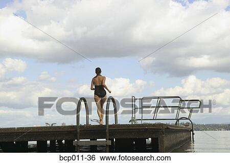Woman preparing to dive into a lake. View Large Photo Image Stock Photograph - Woman preparing to dive into a lake.. Fotosearch
