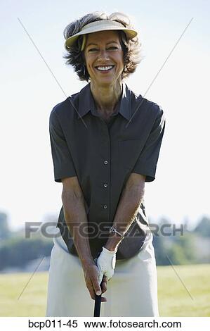 Stock Photography - Woman preparing to swing a golf club.. Fotosearch