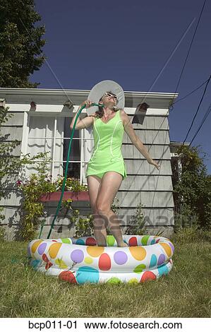 Standartiniai vaizdai - Woman standing in baby pool.. Fotosearch