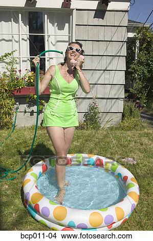 Woman talking on phone while standing in pool. View Large Photo Image Picture - Woman talking on phone while standing in pool.. Fotosearch