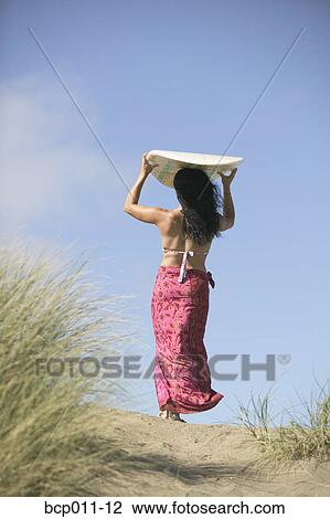 Woman walking outdoors with a surfboard. View Large Photo Image Stock Image - Woman walking outdoors with a surfboard.. Fotosearch