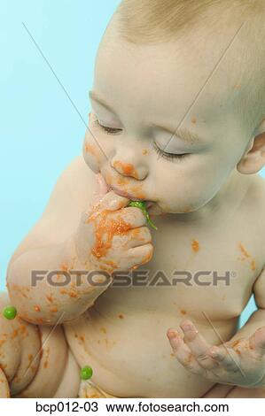 Infant eating baby food with fingers. View Large Photo Image Stock Image - Infant eating baby food with fingers.. Fotosearch