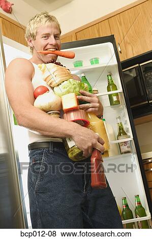 Stock Photo - Man with his arms full of food.. Fotosearch