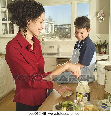 Stock Photography - Mother and son preparing lunch together. . Fotosearch