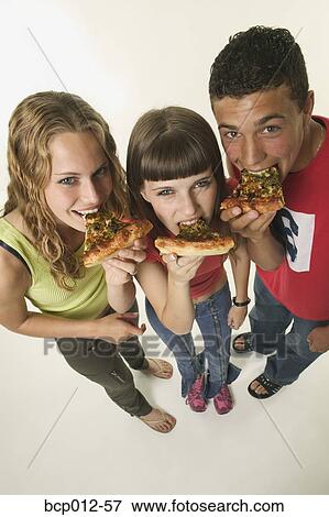 Three teenagers eating pizza. View Large Photo Image Stock Photo - Three teenagers eating pizza.. Fotosearch