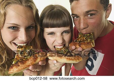 Three teenagers eating pizza. View Large Photo Image Stock Photo - Three teenagers eating pizza.. Fotosearch