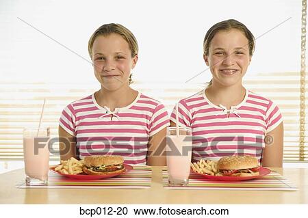 Twin teenagers with hamburgers, french fries, and milkshakes. View Large Photo Image Stock Image - Twin teenagers with hamburgers, french fries, and milkshakes.. Fotosearch