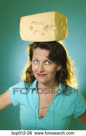 Stock Photo - Woman balancing a block of cheese on her head. . Fotosearch
