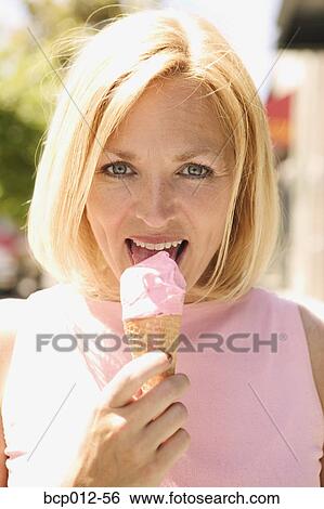 Stock Photograph - Woman eating an ice cream cone. . Fotosearch