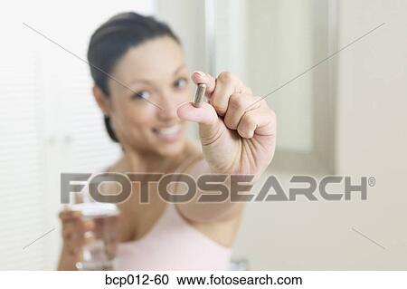 Woman holding a vitamin capsule. View Large Photo Image Stock Image - Woman holding a vitamin capsule.. Fotosearch