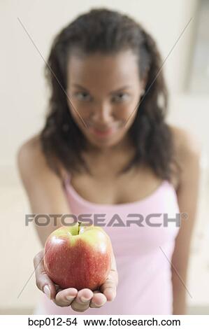 Woman holding an apple. View Large Photo Image Picture - Woman holding an apple.. Fotosearch