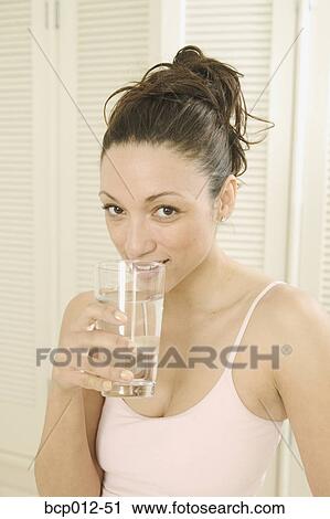 Woman sipping a glass of water. View Large Photo Image Stock Image - Woman sipping a glass of water. . Fotosearch