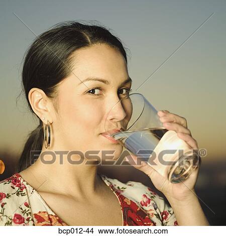 Young woman drinking a glass of water. View Large Photo Image Picture - Young woman drinking a glass of water. . Fotosearch