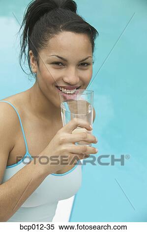 Young woman holding a glass of water. View Large Photo Image Stock Photography - Young woman holding a glass of water. . Fotosearch